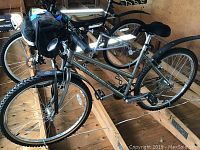 Front-side view of the silver Gary Fisher step-through bike showing handlebar bag, fender and bottle cage