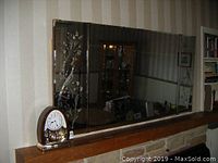 Full view of the wall mirror with three sections showing peacock carvings on side panels.