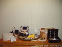 Overview photo showing multiple jewelry boxes, trinket boxes, and various jewelry items arranged on table.