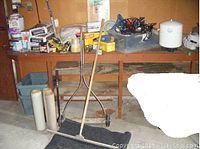 Wide view of various household repair items and supplies on wooden shelving and floor area