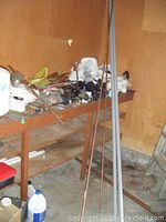 Photo of 13 ft copper pipes, copper tubes standing upright and lying on a wooden table and floor area.