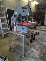 Front left side view of Delta band saw on rolling cart showing table, frame and cart shelves