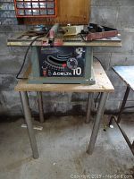 Front view of Delta 31-225C table saw with measurement dial and stand.