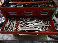 Drawer with combination wrenches and adjustable wrench labeled 'Forges' with various socket pieces above