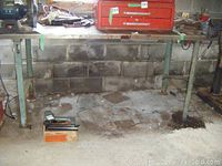 Full view of the heavy duty work bench with steel legs and steel top, showing wear and surface rust.