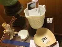 Lot of four items on a table: Belleek vase, heart shaped dish, milk glass hobnail pitcher, and trinket box.