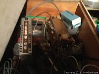 Electronic equipment in wooden crate showing various devices and cables.