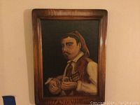 Framed portrait painting of a man in traditional costume playing a stringed instrument
