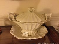 Full view of the covered tureen sitting on the underplate showing the detailed handle and lid knob design.