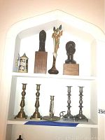 Shelf with two African American wooden sculptures, German stein, Anna Vans Buggle flower vase, and five metal candlesticks