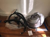 Photo showing the Conair GS28 garment steamer main unit with attached hose and black plastic hanger accessory.