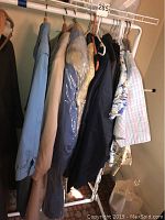 Hanging coats and jackets including light blue coat, taupe coat, and multi-colored jackets on rack
