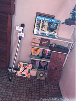 Photo of the collection showing Family Game Chest box, pogo stick, other boxed games, and game accessories stacked on shelves and floor.