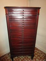 Front view of the hardwood cabinet showing all 21 drawers with numbered gold labels