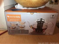 Photo of KitchenKite 1000ml glass teapot infuser and four double wall glass cups in original box, showing brand and product details on box.