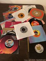 Photo of assorted 45 RPM vinyl records and sleeves laid out on a surface