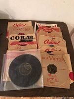 Photo showing a batch of 18 vintage records in original sleeves, labeled RCA Victor, Capitol, Coral.