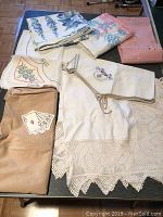 Overview photo showing all seven card table cloths in varied colors and patterns on a table