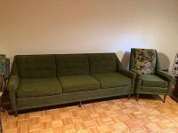 Green mid century modern sofa with tufted cushions and matching upholstered chair