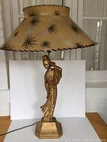 Full view of lamp showing overall shape, figure base and shade