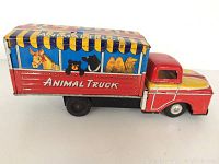 Side view showing the detailed colorful animal illustrations on the cargo box and the red truck cab with yellow and white paint accents.