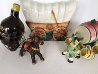 Photo showing two ceramic decanter sets and a white covered wagon light.