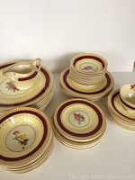 Wide shot of stacked plates and bowls showing pattern and quantity including the creamer and cup