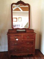 Dresser with mirror attached showing front view of dresser and top of mirror.