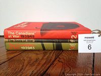 Side view of three hardcover books: two volumes of 'The Canadians at War 1939/45' and one 'The Tools of War'.