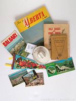 Overview photo of collectibles including booklets, postcards, pennant, and ashtray
