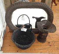 Set of vintage rattan items on wooden floor, including the mirror, basket, and vase grouped together.