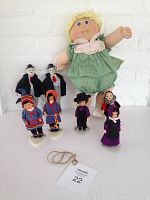 Front view of all seven dolls arranged together showing details of clothing and styles