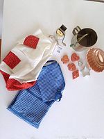 Photo showing all vintage kitchen items including flour sifter, nut grinder, gelatine mould, multiple cookie cutters, and two aprons laid flat with details visible