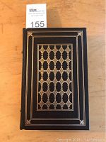 Front cover view of the book showing intricate gilt tooled black leather binding