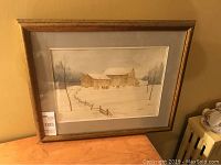 Front view of framed watercolour painting displaying winter barns scene signed Mikus 89.