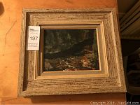 Full view of the framed painting showing textured wooden frame and river gorge scene artwork