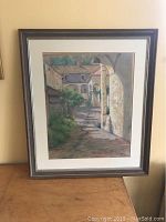 Full view of framed pastel drawing showing the European street scene artwork.