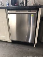 Front view of stainless steel built-in dishwasher installed under countertop