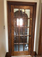 Front view of oak door closed, shows full grid of glass panes and finish