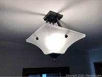 Front angle view of the ceiling light fixture mounted on ceiling showing the shape and hardware.