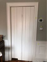 Front view of white folding door closed within its white jamb frame.