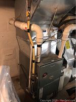 Front view of Ruud furnace cabinet with PVC vent pipes