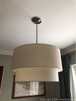 Side view of the hanging pendant light showing two-tier drum shades and brushed nickel canopy
