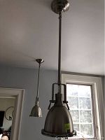 Two pendant lamps installed; larger on left with glass bottom, smaller on right