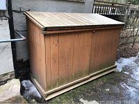 Front view of wooden bin enclosure with closed hinged lid