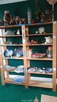 Front view of the six shelf wooden wall unit filled with various decorative items