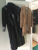 Black Patricia Wolf leather cowboy jacket with tassels and puffed sleeves on hanger