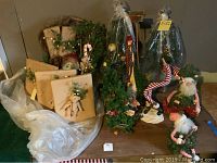 Overall view of the lot showing Santa figurines, wrapped faux packages, faux Christmas trees, snowman figurine, and wreath.