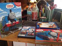 Photo showing entire lot on a desk: DVD, storybook, and playmat with pen, along with desk items in background.