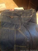 Back view of medium blue denim men's Polo jeans showing the Polo Jeans Company RL patch with American flag on the waistband